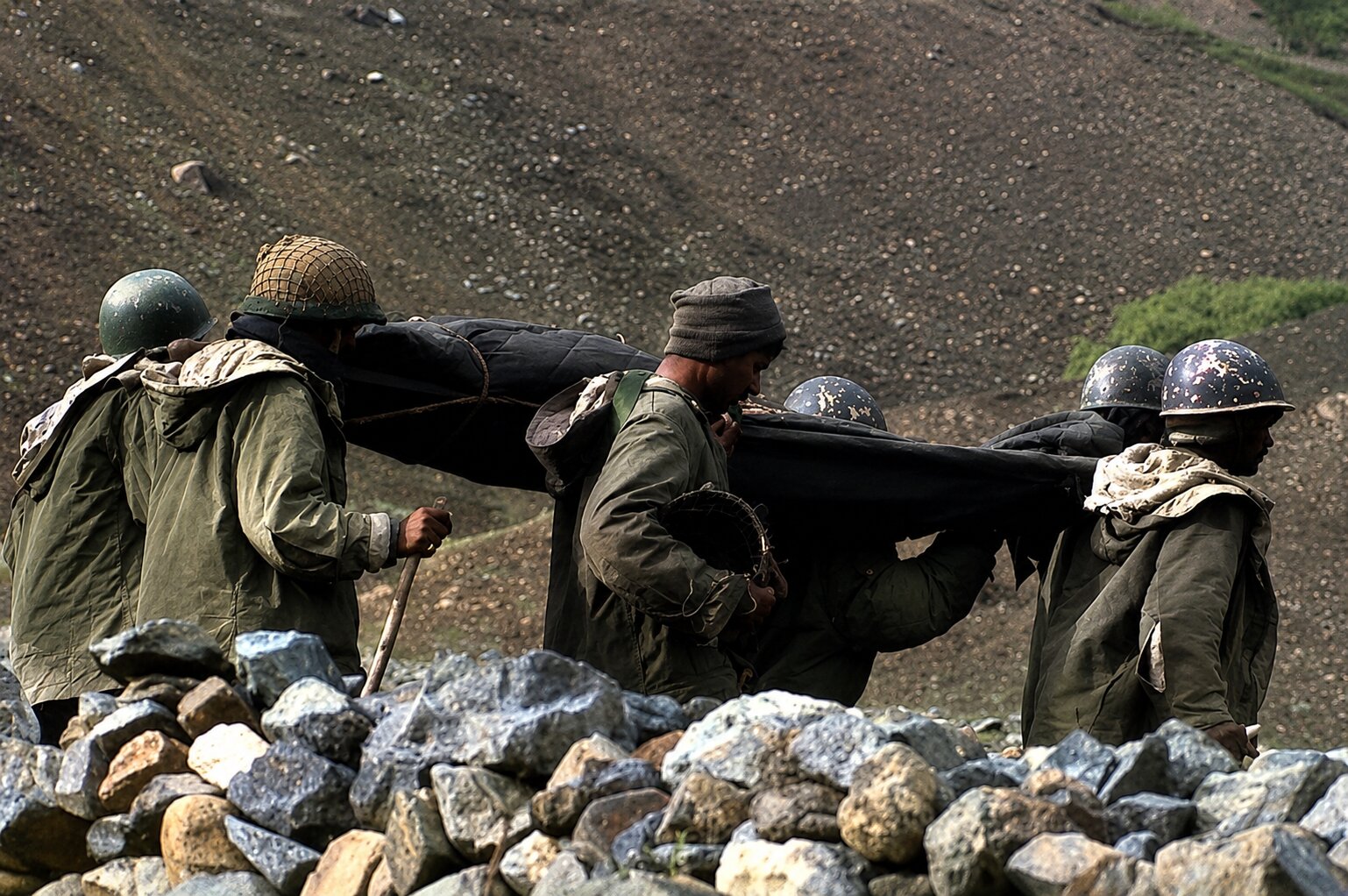 Soldiers carrying a fallen comrade down from the Tololing sector